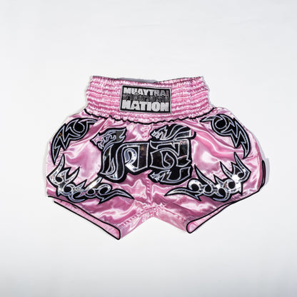 A pair of Muay Thai shorts featuring a satin fabric with a red, green, and white color scheme. The shorts have floral patterns and text that reads 'Muay Thai Nation' and 'BANGKOK'.
