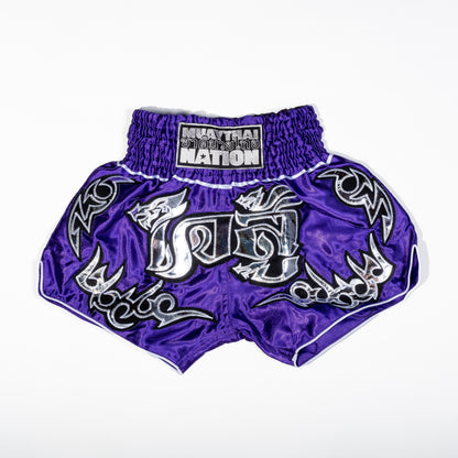 A pair of Muay Thai shorts featuring a satin fabric with a red, green, and white color scheme. The shorts have floral patterns and text that reads 'Muay Thai Nation' and 'BANGKOK'.