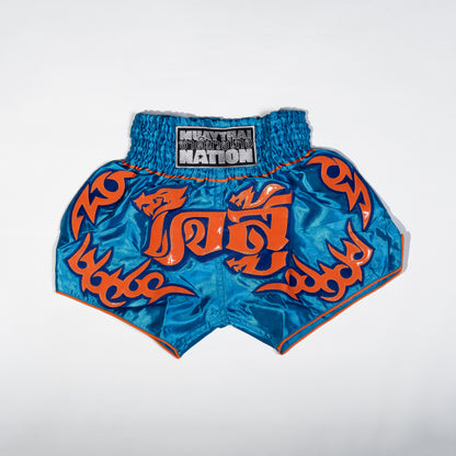 A pair of Muay Thai shorts featuring a satin fabric with a red, green, and white color scheme. The shorts have floral patterns and text that reads 'Muay Thai Nation' and 'BANGKOK'.