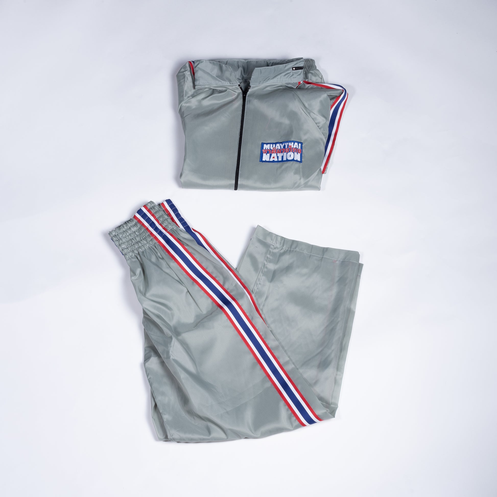 Muay Thai Nation light grey tracksuit jacket and pants with blue, white, and red trim