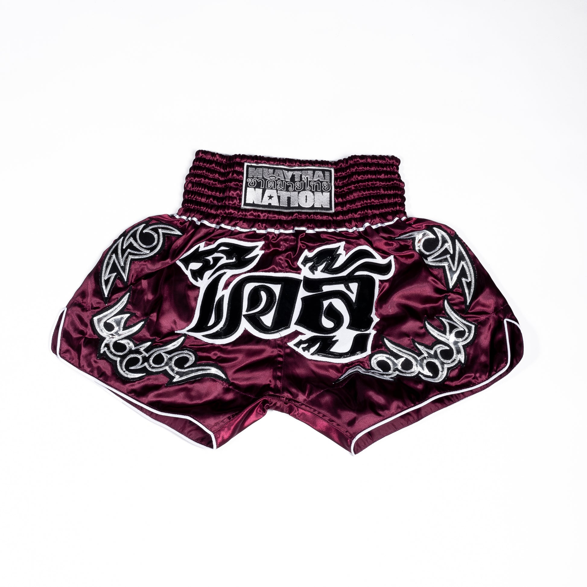 Muay Thai Nation standard black fight shorts with maroon trim and retro lettering.