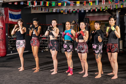 Women's muay thai fighters wearing colourful muay thai shorts paired with custom muay thai hand wraps.

