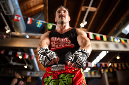 Muay thai fighter wearing black and white hand wraps.
