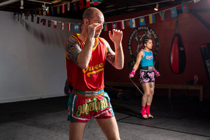 Red, yellow and green lucky 7 Muay Thai shorts and oweey tank set worn during Muay Thai shadowboxing.
