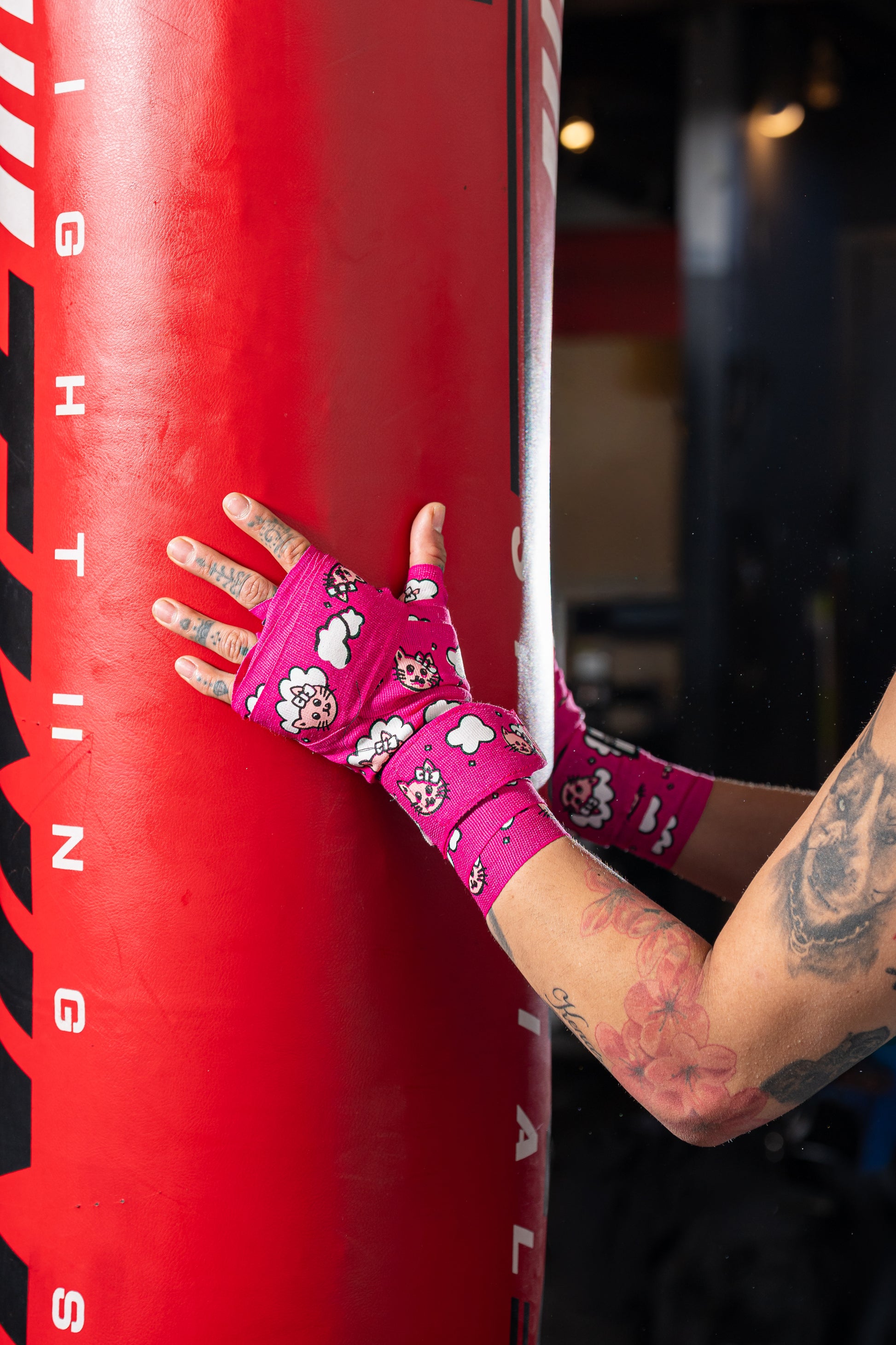 Women's hands wearing pink muay thai hand wraps.